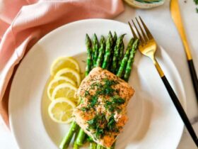 Air Fryer Salmon — Perfectly Flaky, Juicy, and Ready in 12 Minutes 18 Air fryer salmon fillets plated beautifully on a white dish with lemon slices, fresh dill, and a side of roasted asparagus