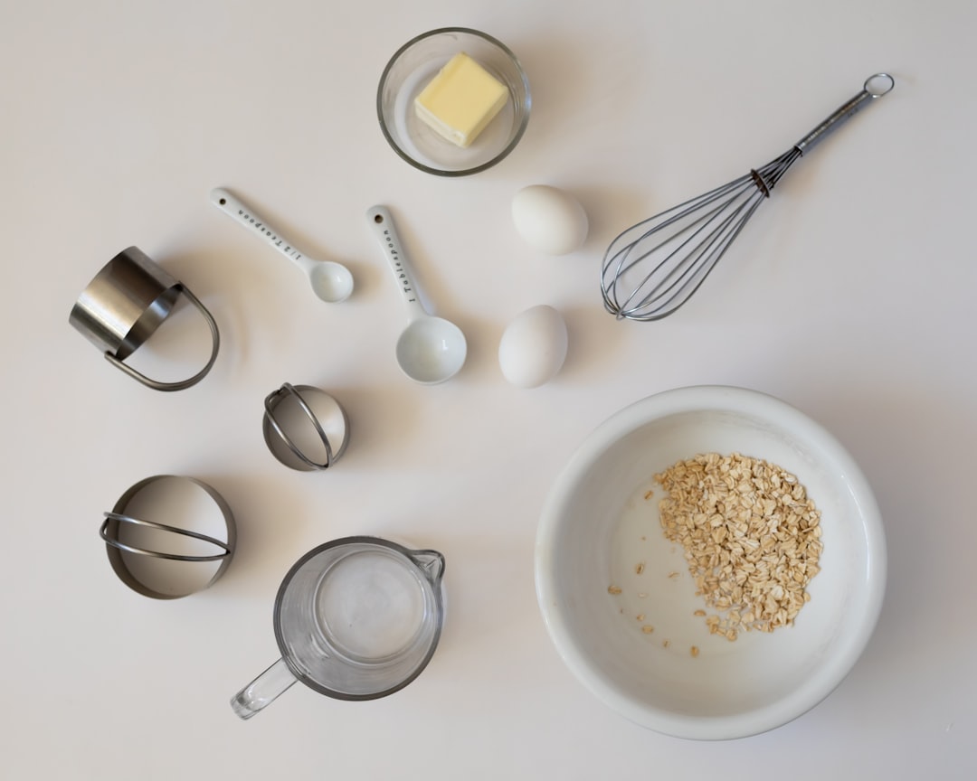 Bisque Cheesecake ingredients laid out on a marble countertop — cream cheese blocks, eggs, heavy cream, graham crackers, butter, and vanilla extract in a flat lay overhead shot