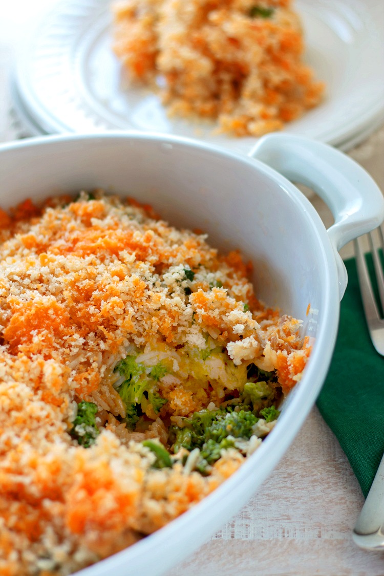 flat lay of chicken broccoli rice casserole ingredients including shredded rotisserie chicken, broccoli florets, cooked rice, shredded cheddar, and cream sauce in individual bowls on a marble surface