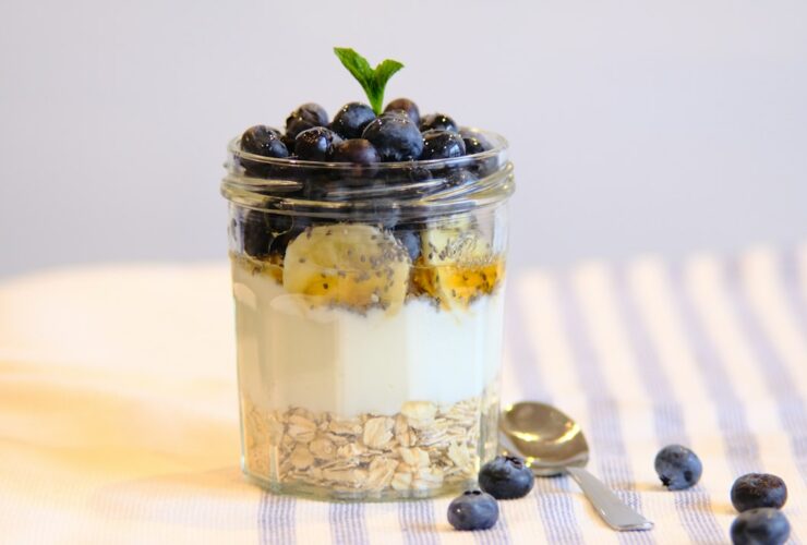 Coconut Chia Pudding Parfait Breakfast — The Make-Ahead Morning That Tastes Like Vacation 51 Coconut chia pudding parfait in a tall glass jar layered with mango, pineapple, toasted coconut flakes, and a drizzle of honey on a bright white marble surface with tropical greenery in the background