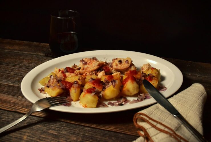 Coq au Vin served in a wide shallow bowl with tender chicken thighs, mushrooms, pearl onions, and glossy red wine sauce, garnished with fresh thyme
