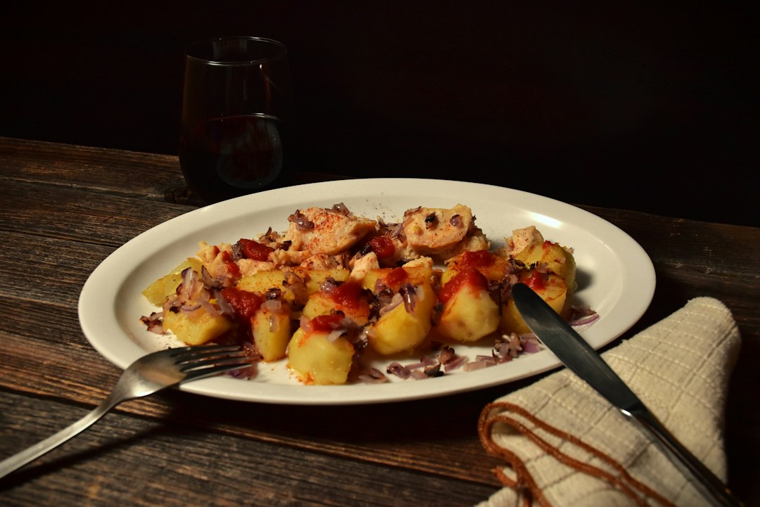 Coq au Vin served in a wide shallow bowl with tender chicken thighs, mushrooms, pearl onions, and glossy red wine sauce, garnished with fresh thyme