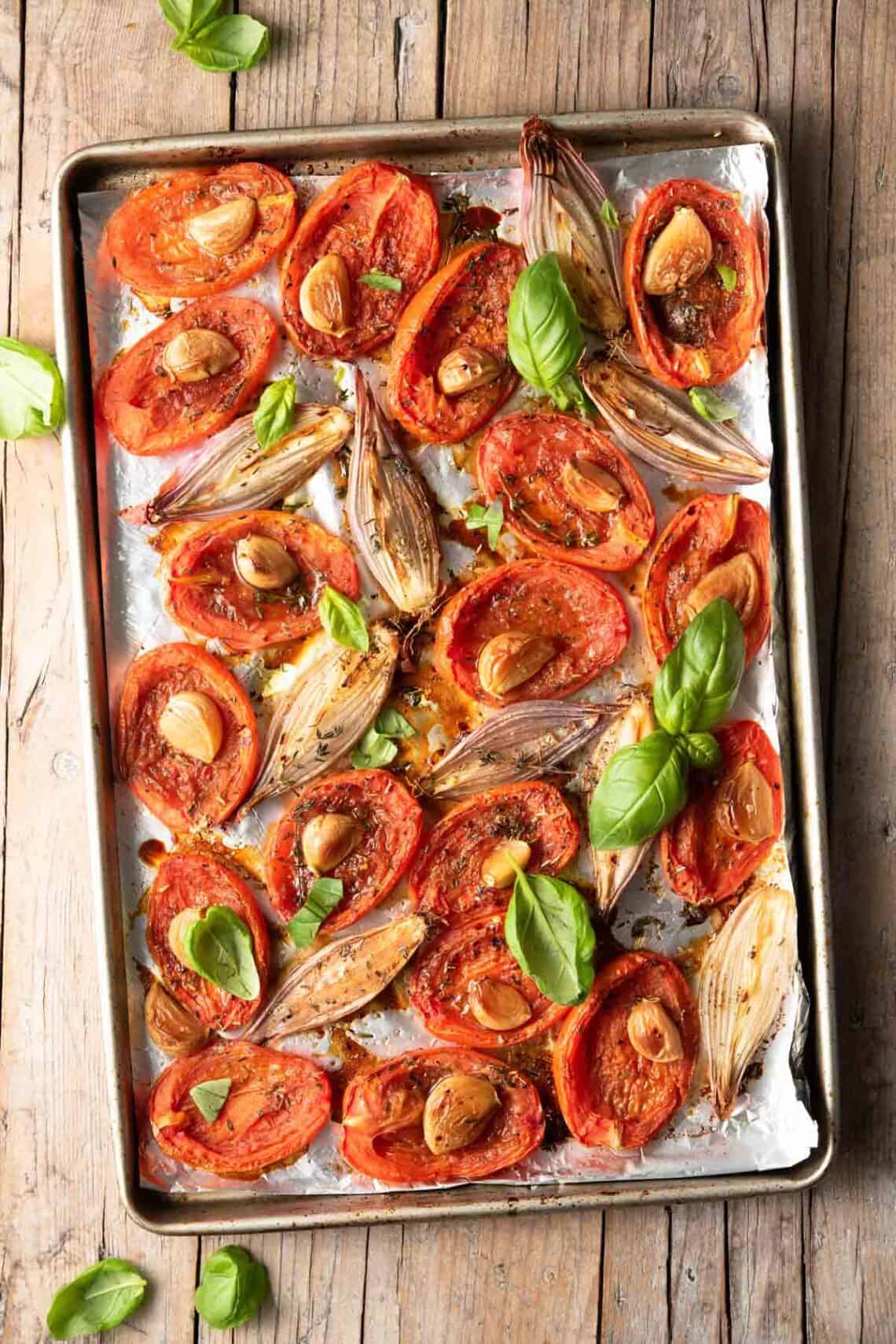 Creamy Tomato Basil Soup — Roasted Tomato Soup Built for Grilled Cheese Dunking 27 A sheet pan of halved roma tomatoes, shallots, and a whole head of garlic drizzled with olive oil and sprinkled with salt, ready to go into the oven for roasting
