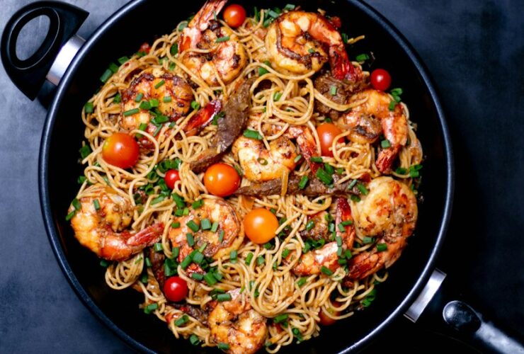 Creamy Tuscan Chicken served in a white skillet with golden pan-seared chicken breasts nestled in a rich spinach and sun-dried tomato cream sauce, garnished with fresh basil
