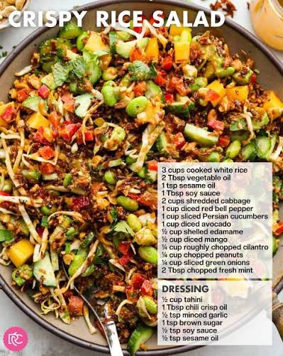 Overhead flat-lay of crispy rice salad ingredients on a light surface — bowls of day-old jasmine rice, sliced cucumbers, edamame, shredded purple cabbage, diced avocado, sesame seeds, and small jars of sesame oil and soy sauce
