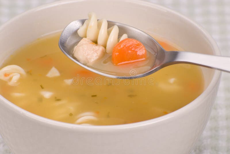 Crockpot Chicken Noodle Soup — The Ultimate From-Scratch Slow Cooker Comfort Bowl 28 A close-up side-angle shot of a white ceramic bowl of Crockpot Chicken Noodle Soup, steam rising, with a wooden spoon resting in the bowl and fresh parsley scattered around on a linen napkin