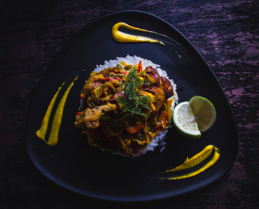 Cuban Ropa Vieja — Tender Shredded Beef in Rich Tomato Sofrito Sauce 26 Cuban Ropa Vieja served over white rice in a wide bowl, topped with fresh cilantro and sliced olives, photographed on a rustic wooden table with warm lighting