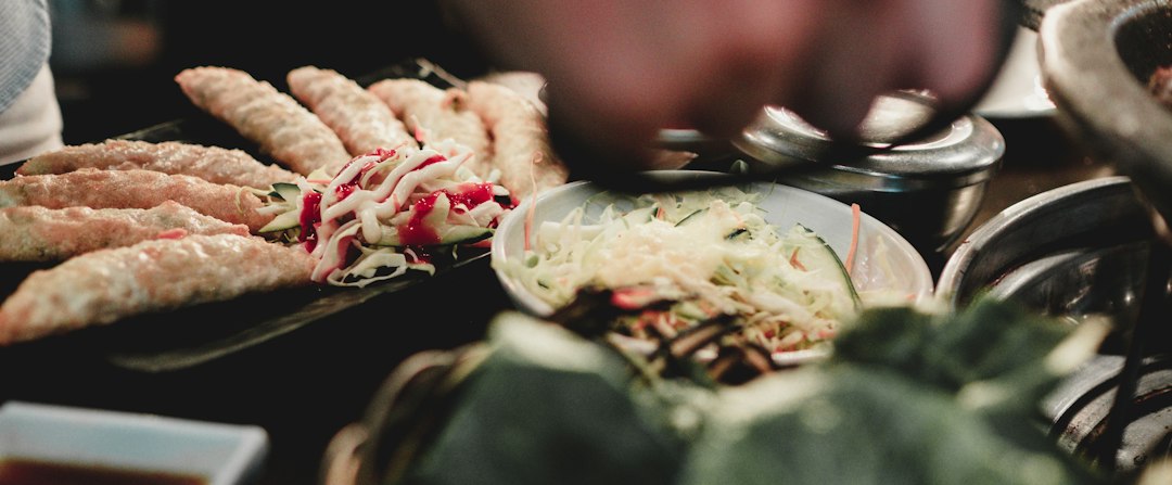 Close-up of grilled shrimp skewers with visible char marks, garnished with fresh lemon slices and chopped parsley, served alongside a creamy dipping sauce