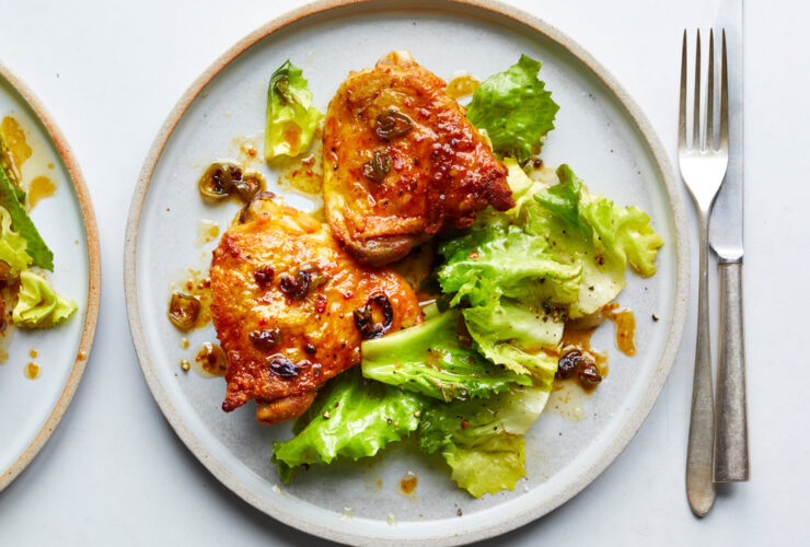 Hot Honey Chicken plated on a white ceramic dish with a glossy sweet-heat glaze, garnished with fresh thyme and chili flakes, served alongside roasted vegetables