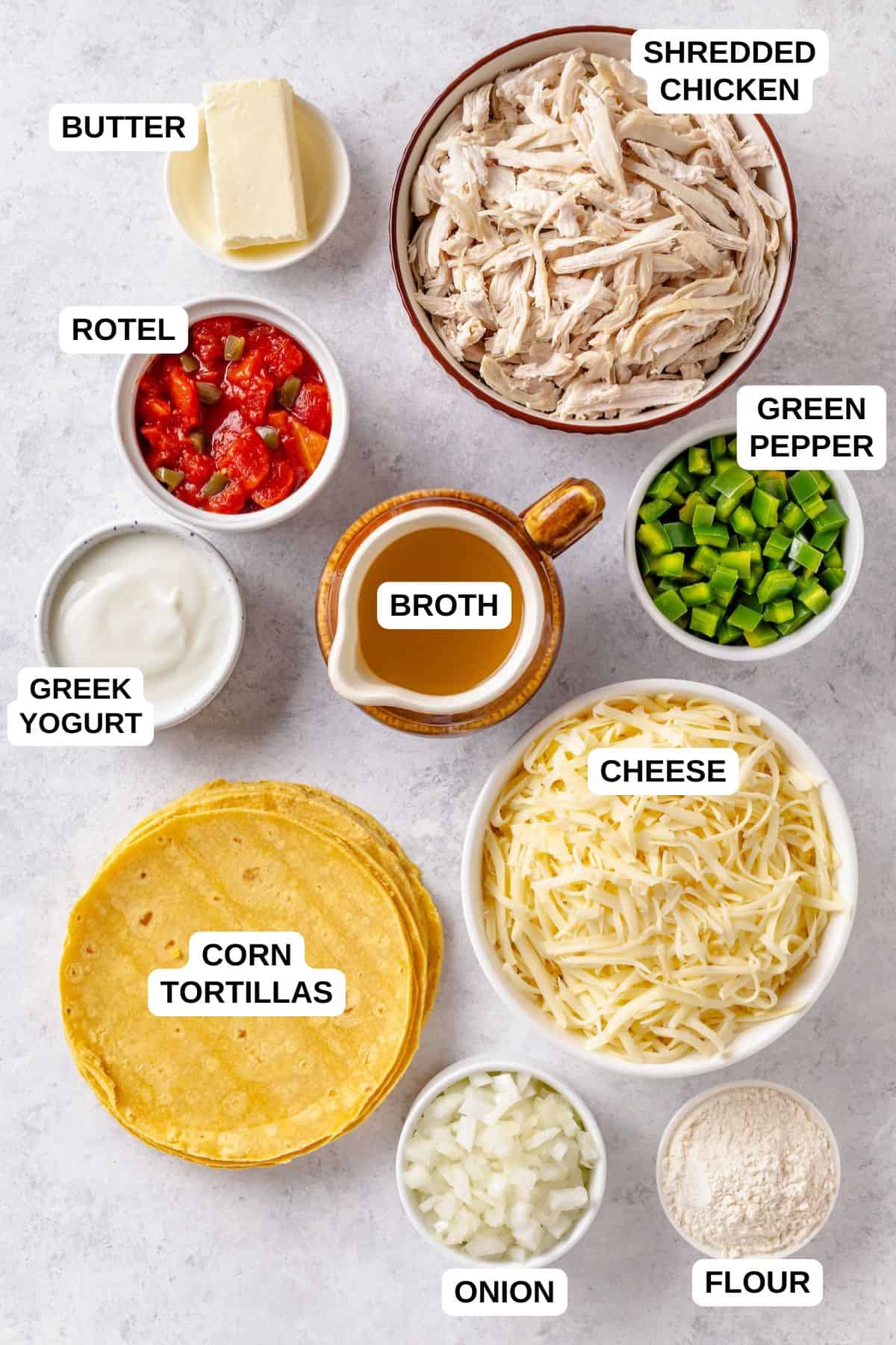 Overhead flat-lay of King Ranch Chicken Casserole ingredients including shredded chicken, corn tortillas, green chiles, cheddar cheese, and diced tomatoes on a white marble surface