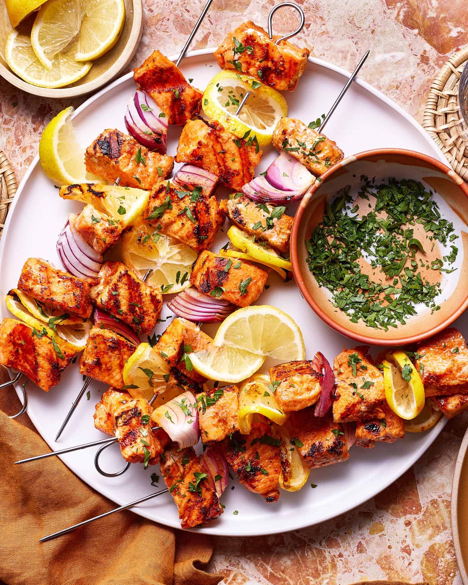 Lemon Garlic Salmon Skewers — Bright, Bold, and Ready in 30 Minutes 28 close-up of grilled lemon garlic salmon skewers on a wooden serving platter with a wedge of lemon being squeezed over the top and scattered fresh parsley