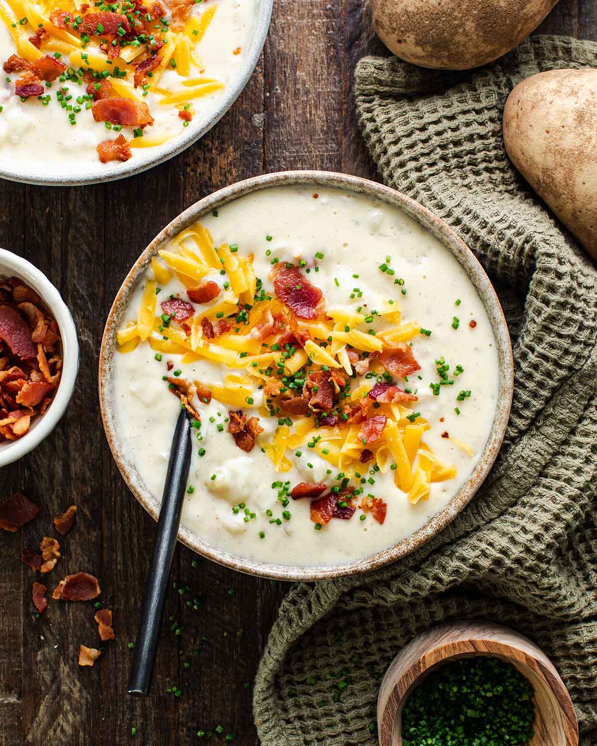 Loaded Baked Potato Soup — Creamy, Hearty & Worth Every Spoonful 27 Overhead flat-lay of loaded baked potato soup ingredients including diced russet potatoes, strips of thick-cut bacon, a block of sharp cheddar cheese, sour cream, chicken broth, butter, garlic, and fresh chives on a marble surface