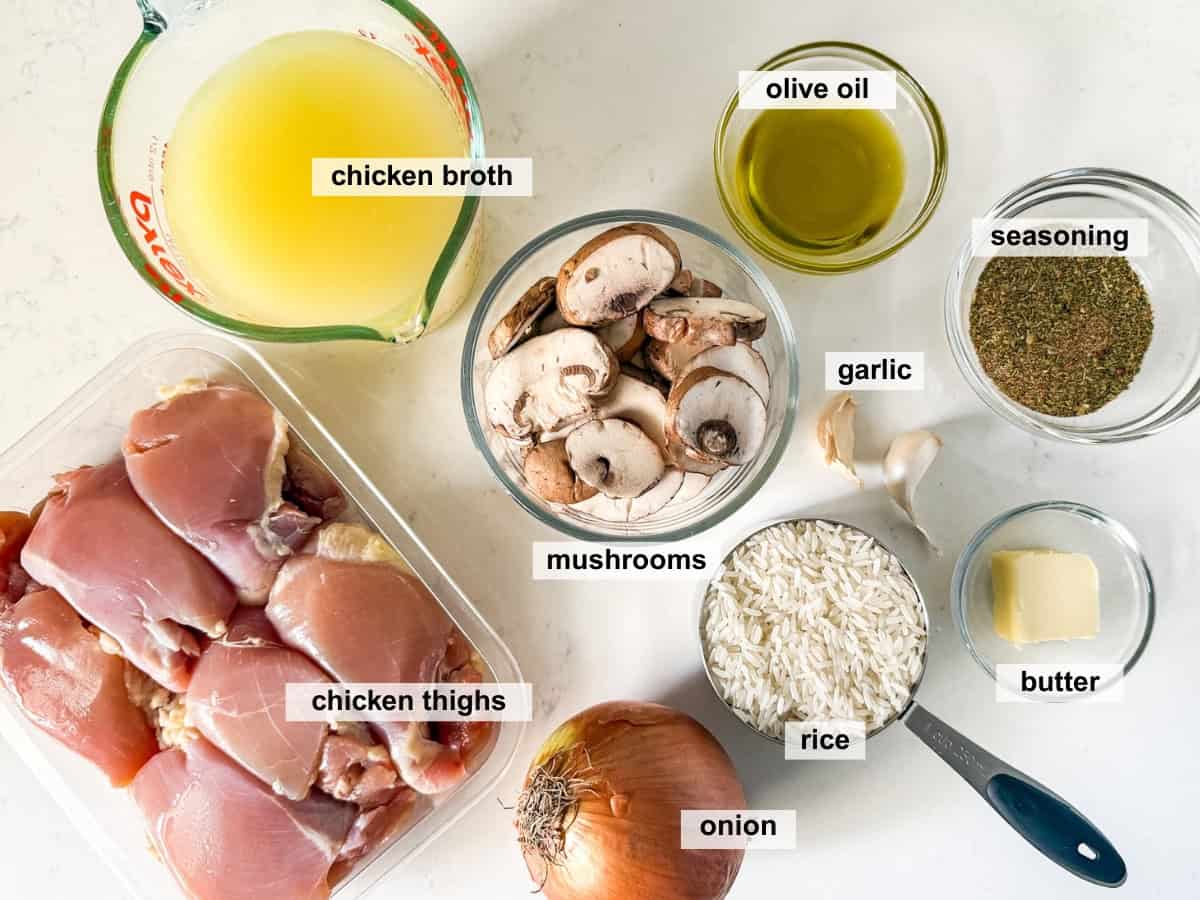 One Pan Chicken and Rice — The Easy, Nourishing Weeknight Dinner That Does It All 27 Overhead shot of ingredients for One Pan Chicken and Rice arranged on a wooden board — raw chicken thighs, uncooked rice, broth, onion, garlic, paprika, cumin, and fresh parsley