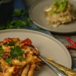One Pot Creamy Cajun Chicken Pasta served in a wide skillet with andouille sausage, colorful bell peppers, and a golden creamy sauce, garnished with fresh parsley