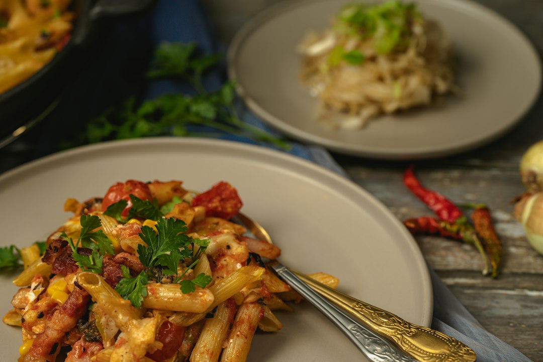 One Pot Creamy Cajun Chicken Pasta served in a wide skillet with andouille sausage, colorful bell peppers, and a golden creamy sauce, garnished with fresh parsley