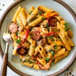 One Pot Creamy Cajun Chicken Pasta served in a wide skillet with andouille sausage, colorful bell peppers, and a golden creamy sauce, garnished with fresh parsley