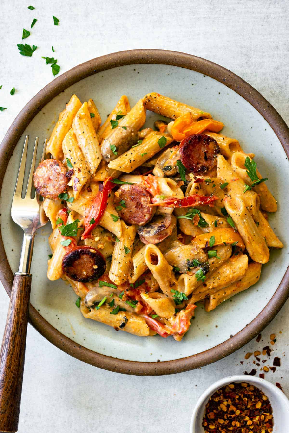One Pot Creamy Cajun Chicken Pasta — Spicy, Smoky & Ready in 45 Minutes 26 One Pot Creamy Cajun Chicken Pasta served in a wide skillet with andouille sausage, colorful bell peppers, and a golden creamy sauce, garnished with fresh parsley