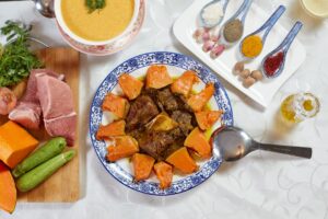 Slow cooker beef stew served in a rustic white bowl with fork-tender beef chunks, golden carrots, soft potatoes, and glistening herb gravy, garnished with fresh thyme on a wooden table