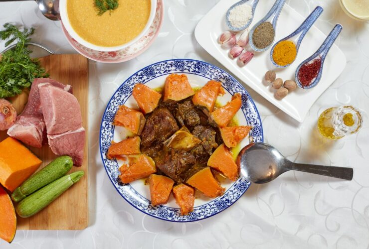 Slow cooker beef stew served in a rustic white bowl with fork-tender beef chunks, golden carrots, soft potatoes, and glistening herb gravy, garnished with fresh thyme on a wooden table