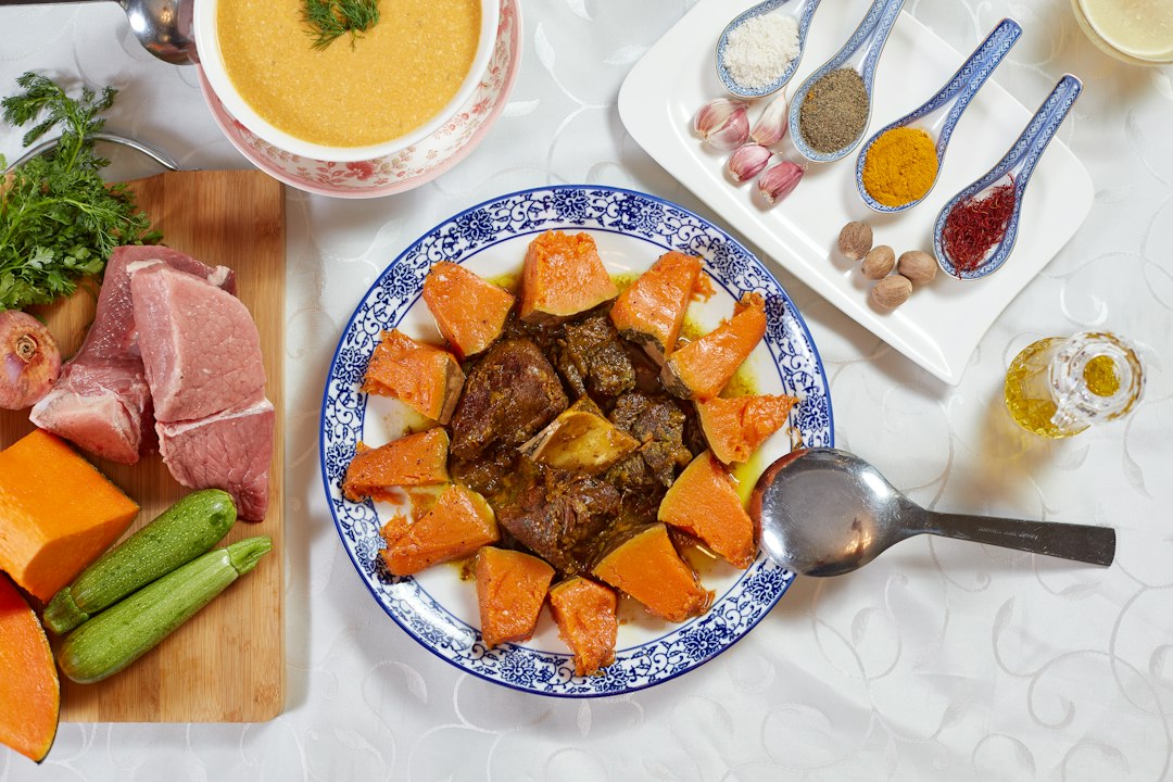 Slow cooker beef stew served in a rustic white bowl with fork-tender beef chunks, golden carrots, soft potatoes, and glistening herb gravy, garnished with fresh thyme on a wooden table