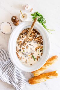 Slow Cooker Chicken Wild Rice Soup — Creamy, Hearty & Deeply Nourishing 13 Slow cooker chicken wild rice soup served in a rustic white bowl, garnished with fresh thyme, steam rising, on a wooden table with a cozy linen napkin