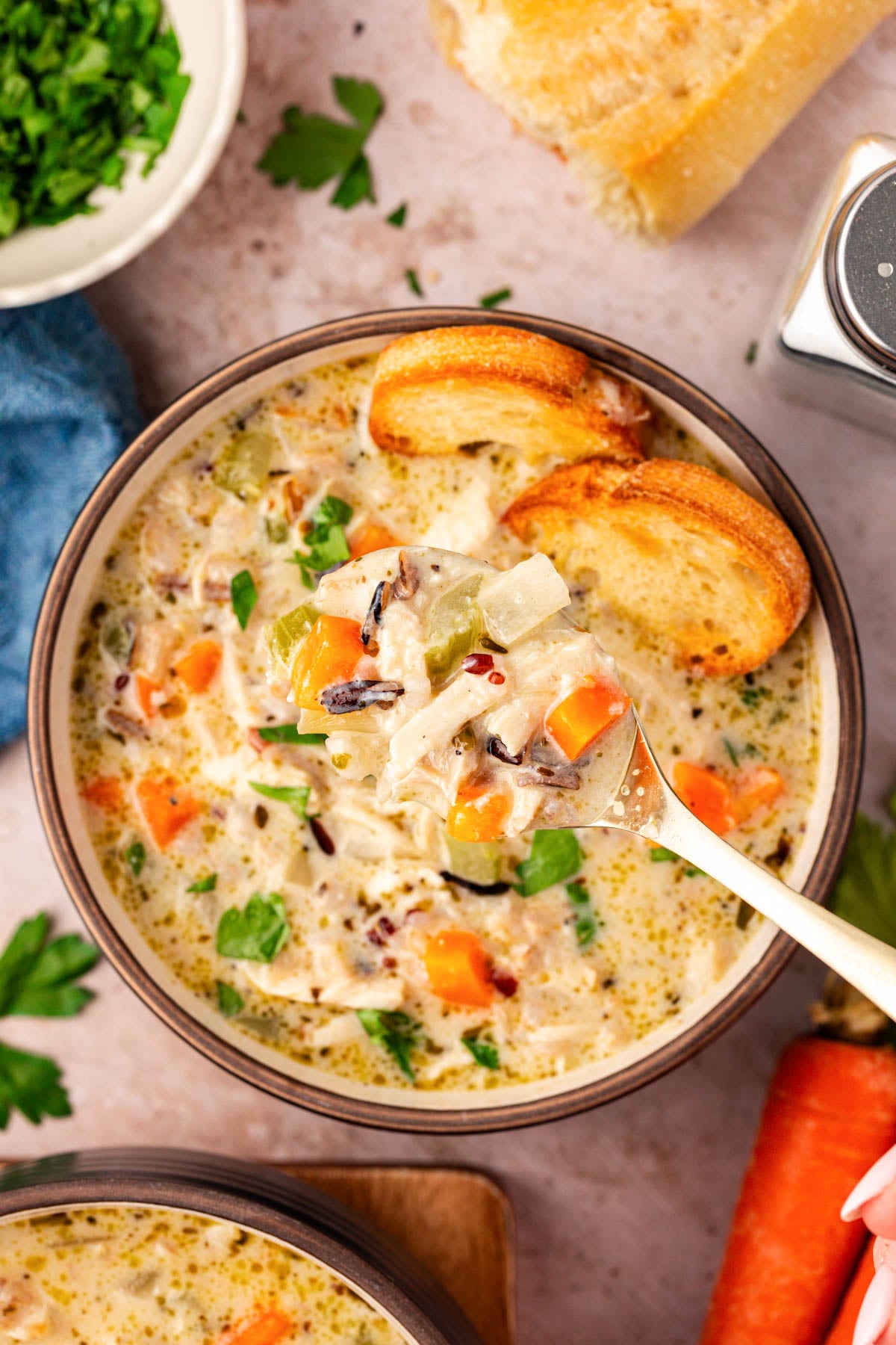 Slow Cooker Chicken Wild Rice Soup — Creamy, Hearty & Deeply Nourishing 28 Close-up of a ladle lifting creamy chicken wild rice soup from the crockpot, showing shredded chicken, wild rice grains, and colorful vegetables