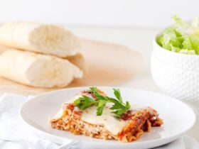 Slow Cooker Lasagna — Layered, Cheesy & Made Right in the Crock 36 Slow cooker lasagna served on a white plate with fresh basil and a side salad, beautifully plated and golden cheesy on top