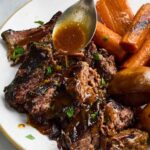 Slow cooker pot roast with tender chuck roast, carrots, potatoes, and rich savory gravy served in a rustic bowl, beautifully plated