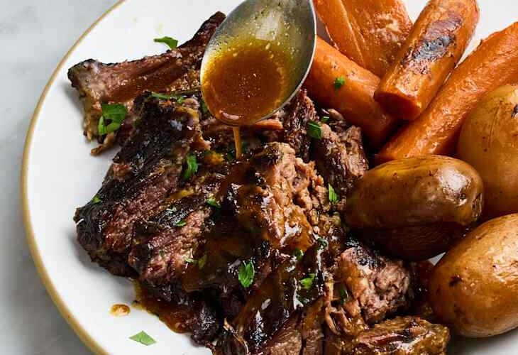 Slow cooker pot roast with tender chuck roast, carrots, potatoes, and rich savory gravy served in a rustic bowl, beautifully plated
