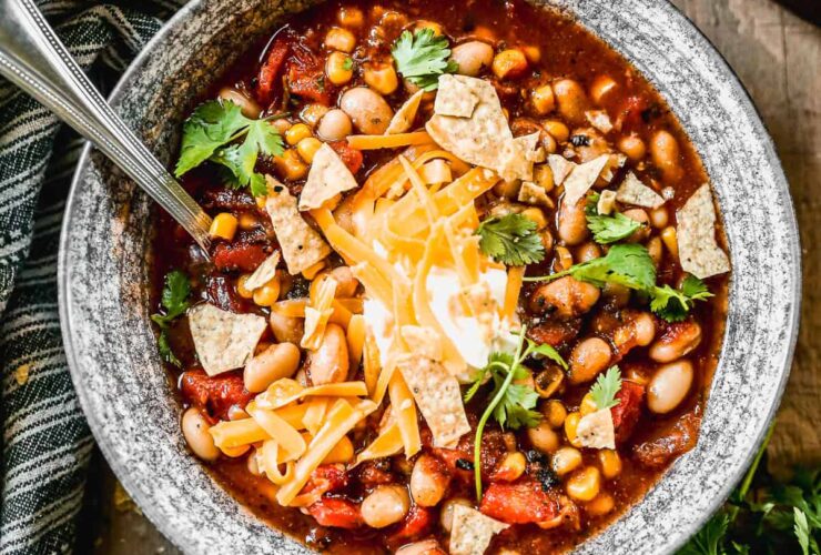 Taco Soup — One-Pot Ground Beef Comfort in Every Spoonful 27 A steaming bowl of taco soup topped with shredded cheese, sour cream, sliced jalapeños, and fresh cilantro, photographed on a rustic wooden table with warm golden light