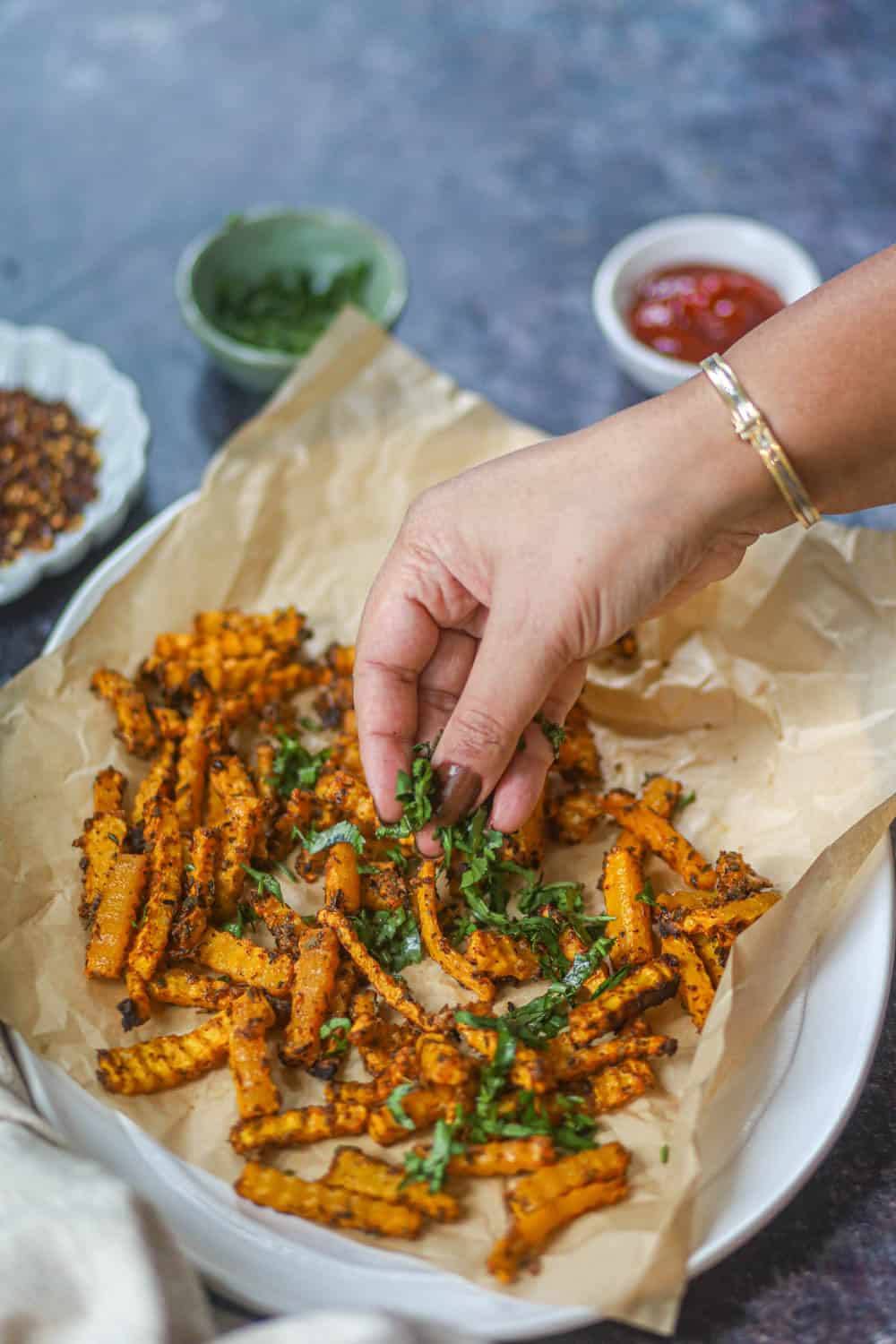 Air Fryer Butternut Squash Fries (Crispy, Healthy & Ready in 25 Minutes) 10 Golden crispy air fryer butternut squash fries arranged on a white plate with a small bowl of Greek-yogurt chipotle dip, garnished with fresh cilantro and a lime wedge