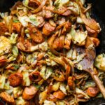 Cabbage and sausage skillet in a cast-iron pan with golden caramelized cabbage and sliced smoked sausage, garnished with fresh parsley