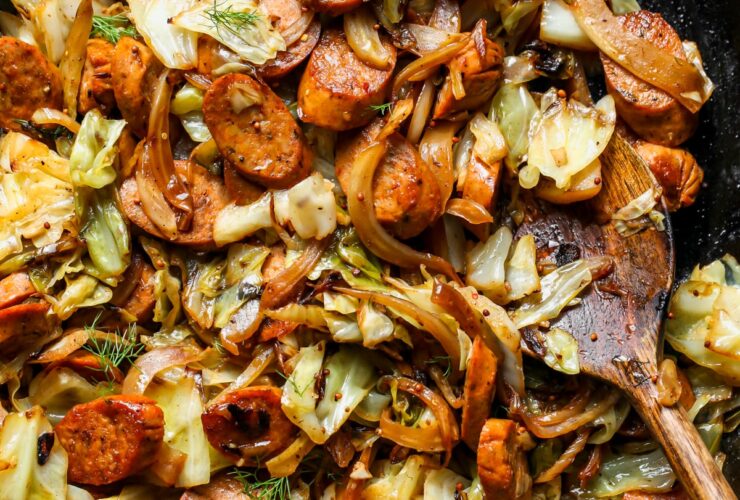 Cabbage and sausage skillet in a cast-iron pan with golden caramelized cabbage and sliced smoked sausage, garnished with fresh parsley