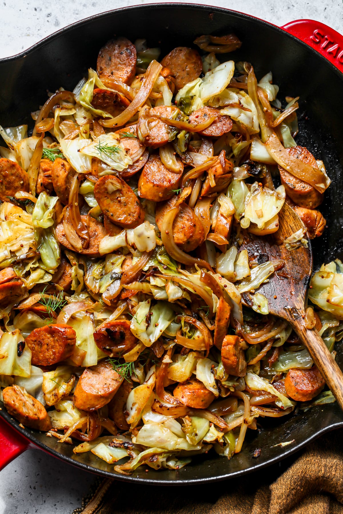 Cabbage and sausage skillet in a cast-iron pan with golden caramelized cabbage and sliced smoked sausage, garnished with fresh parsley