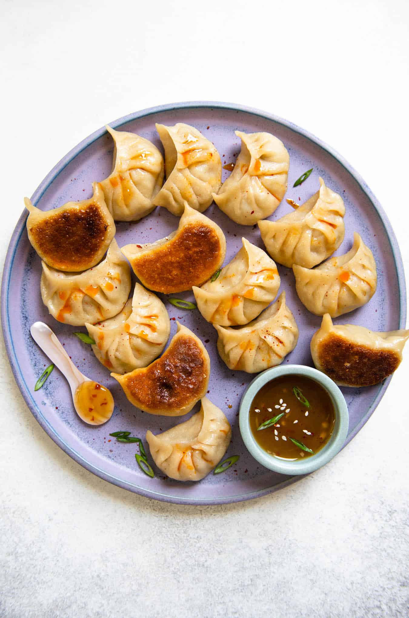 Close-up of a single cabbage dumpling broken open to show the juicy pork and cabbage filling inside