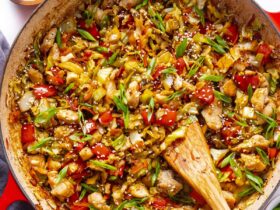 Cabbage stir fry in a hot wok with golden caramelized edges, garlic, ginger, and sesame seeds on a white plate