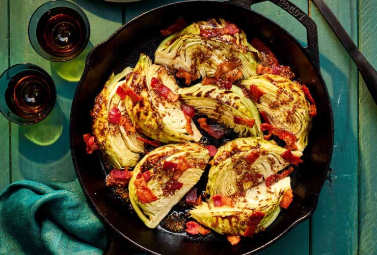 Southern fried cabbage with bacon in a cast iron skillet, garnished with fresh cracked black pepper and green onions, golden and caramelized