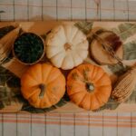 Overhead flat lay of Greek yogurt pumpkin muffin ingredients — pumpkin puree, Greek yogurt, eggs, maple syrup, whole-wheat pastry flour, and spices on a marble surface
