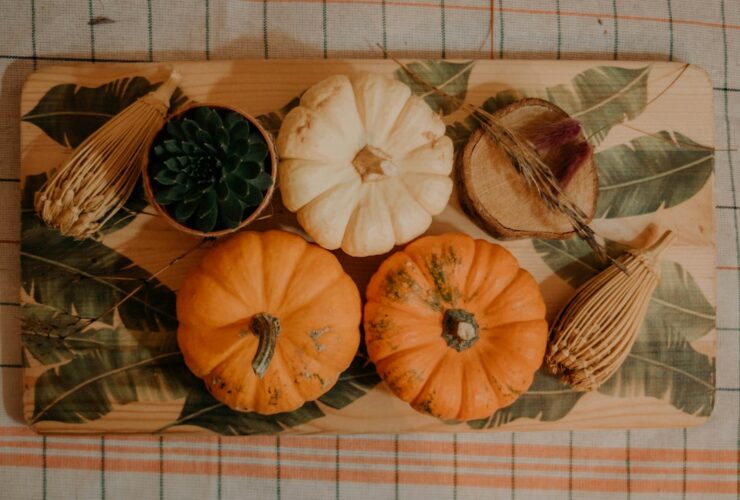 Overhead flat lay of Greek yogurt pumpkin muffin ingredients — pumpkin puree, Greek yogurt, eggs, maple syrup, whole-wheat pastry flour, and spices on a marble surface