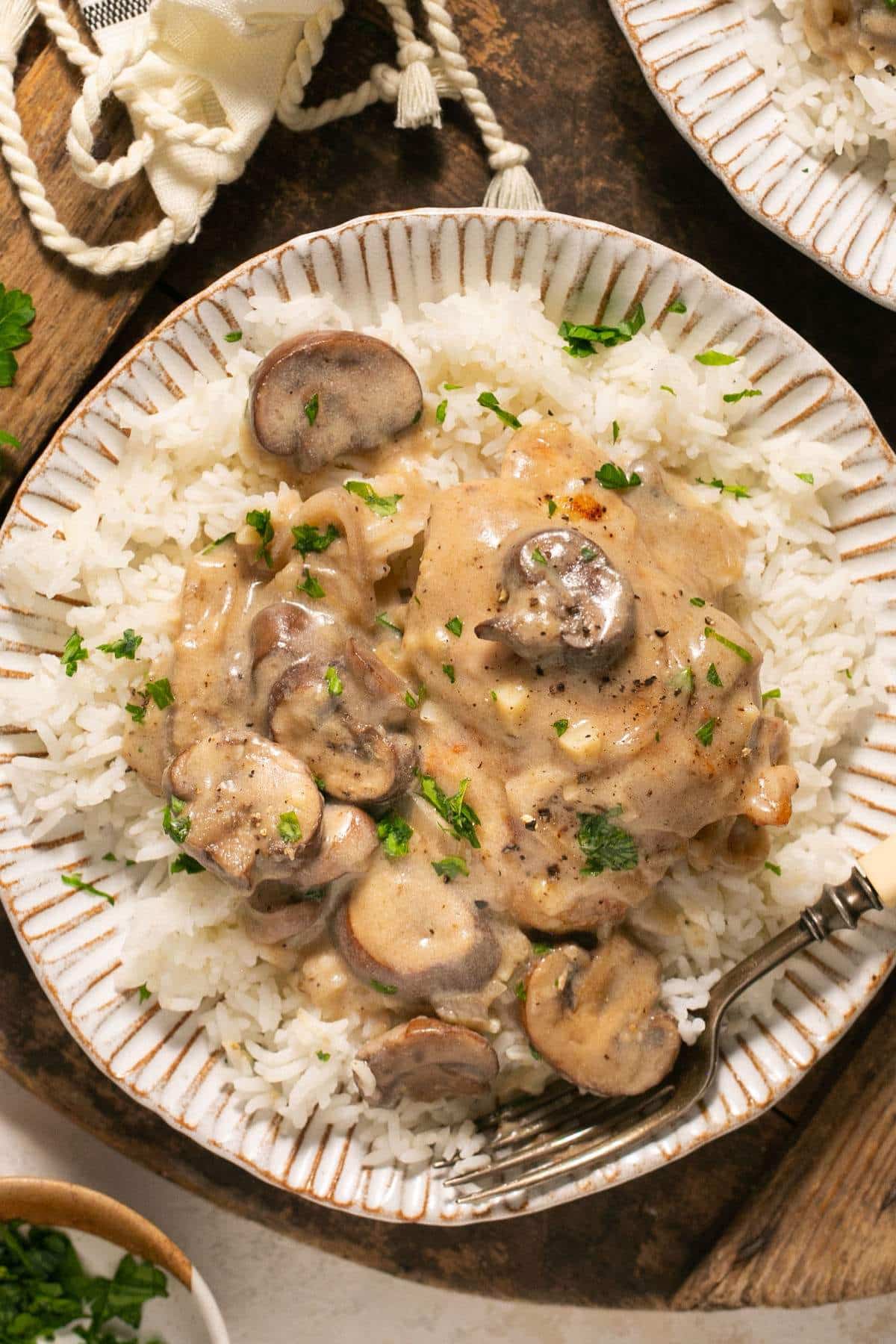 Healthier Chicken and Rice Casserole — Creamy, Comforting & Clean 12 Close-up of a spoonful of healthier chicken and rice casserole being lifted from the dish, showing creamy mushroom sauce, tender chicken chunks, and fluffy brown rice
