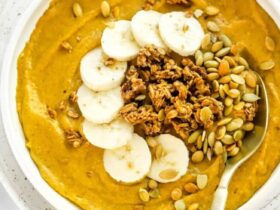 High Protein Fall Smoothie Bowl — Pumpkin, Banana & Greek Yogurt with Granola Crunch 17 High protein fall smoothie bowl topped with granola, banana slices, pumpkin seeds, and a dusting of cinnamon, photographed overhead on a warm wooden surface with autumn leaves in the background