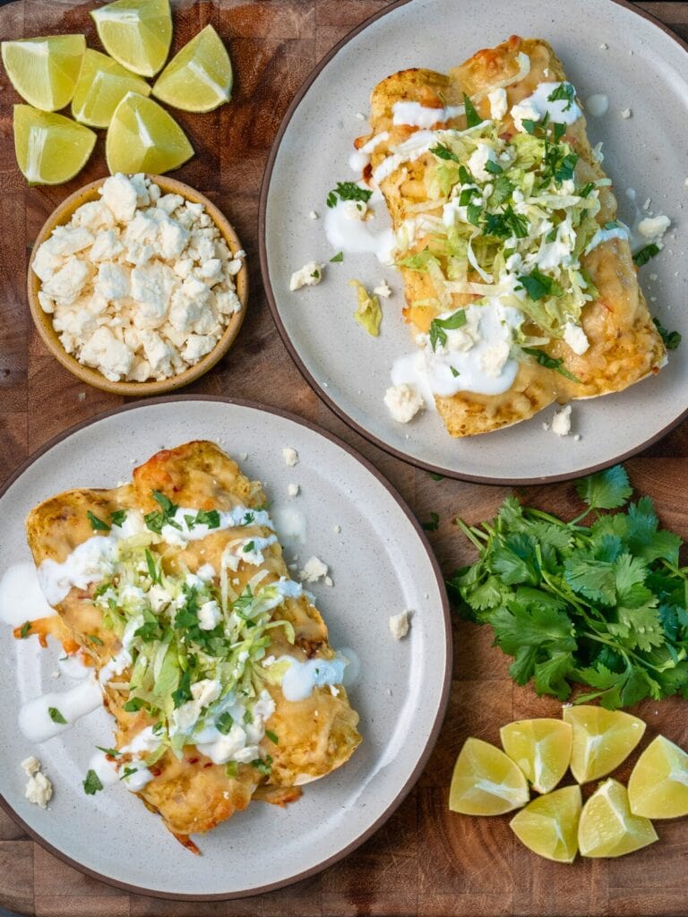 Ingredients for lightened-up chicken enchiladas laid out on a counter — whole-wheat tortillas, shredded chicken, cottage cheese, Greek yogurt, green enchilada sauce, and spices