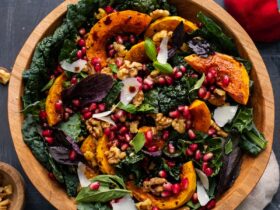 lighter autumn harvest salad with massaged kale, roasted butternut squash, farro, apple, and pomegranate arils in a wide wooden bowl with maple-dijon vinaigrette