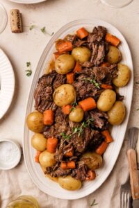 Lighter Beef Pot Roast — Clean, Nourishing & Fall-Apart Tender 13 Lighter beef pot roast with root vegetables and rich broth served in a rustic Dutch oven on a wooden table