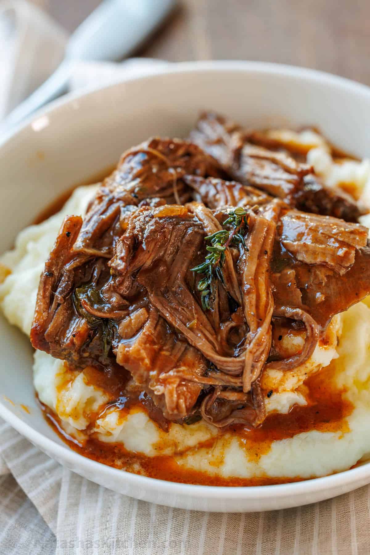 Lighter Beef Pot Roast — Clean, Nourishing & Fall-Apart Tender 12 Close-up of fall-apart lighter beef pot roast with glossy braising sauce and tender root vegetables in a white bowl