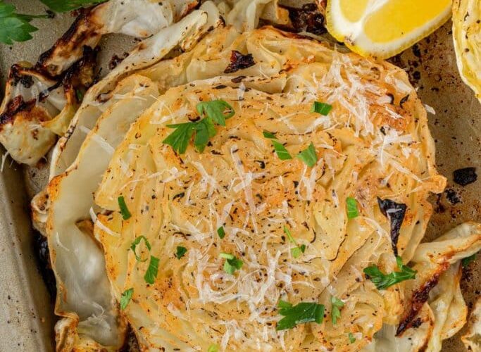 Roasted Cabbage Steaks — Crispy-Edged, Caramelized & Surprisingly Addictive 27 Roasted cabbage steaks on a sheet pan with crispy golden edges, drizzled with olive oil and garnished with fresh parsley