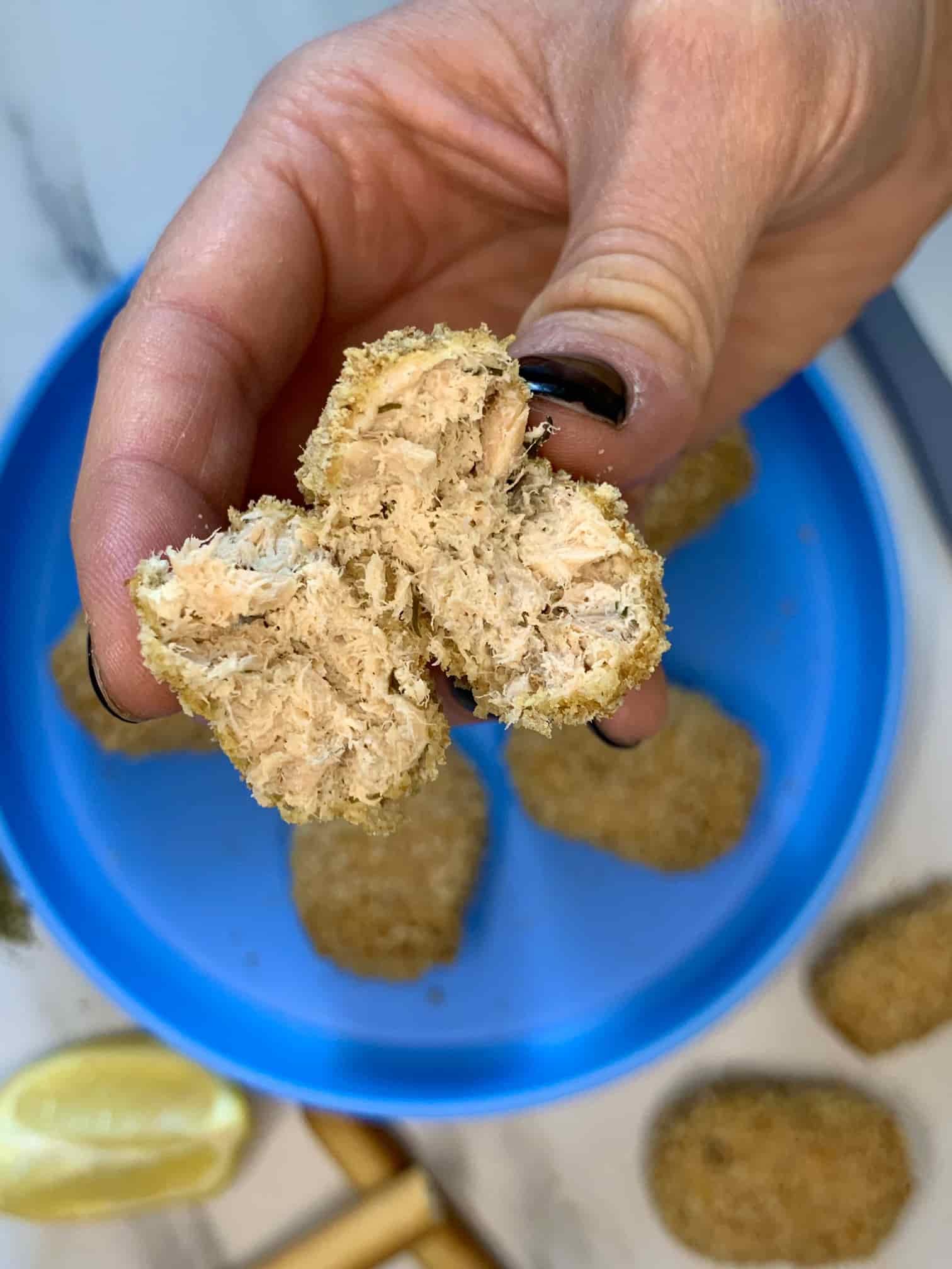 Crispy Air Fryer Salmon Nuggets (Healthy, Easy & Ready in 20 Minutes) 12 close-up of a single salmon nugget broken in half to reveal the flaky, tender salmon interior against the golden panko crust, served with a wedge of lemon