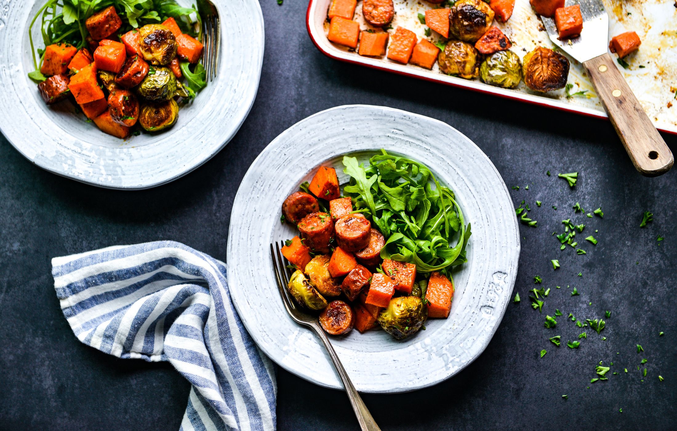 Sheet Pan Turkey Sausage and Fall Vegetables — Easy, Nourishing One-Pan Dinner 12 Close-up of sliced turkey sausage and caramelized fall vegetables on a white plate, garnished with fresh parsley and a wedge of lemon