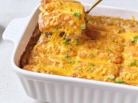 Tater Tot Casserole — Crispy, Cheesy Ground Beef Comfort Food the Whole Family Will Love 30 Golden tater tot casserole fresh from the oven in a white baking dish, with crispy tots on top and melted cheese bubbling at the edges, styled on a rustic wooden table