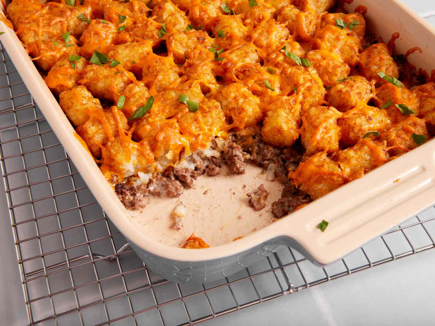 Tater Tot Casserole — Crispy, Cheesy Ground Beef Comfort Food the Whole Family Will Love 27 Overhead flat-lay of tater tot casserole ingredients: raw ground beef, shredded cheddar, cream of mushroom soup can, diced onion, garlic, frozen tater tots, and seasonings arranged on a light marble surface